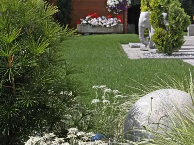 Dichter Fertigrasen und ein alpines Kiesbeet als Beispiel moderner Gartenpflege.