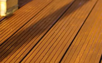 Nahaufnahme von braunen, geriffelten Holzdielen im warmen Licht. Hochwertige Terrassen aus Holz für den Außenbereich.