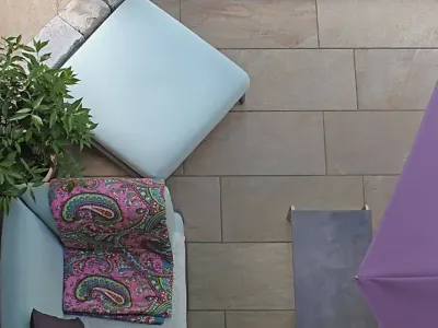 Gemütlicher Sitzbereich auf modernen Terrassenplatten als Teil einer hochwertigen Gartengestaltung.