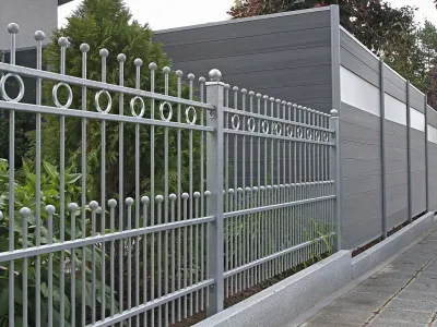 Ein eleganter Metallzaun kombiniert mit modernem Sichtschutz schützt diese gepflegte Gartenanlage.