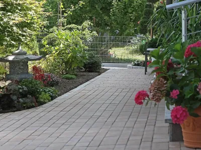 Ein sauber verlegter Gartenweg aus Pflastersteinen im Rahmen der professionellen Gartengestaltung.