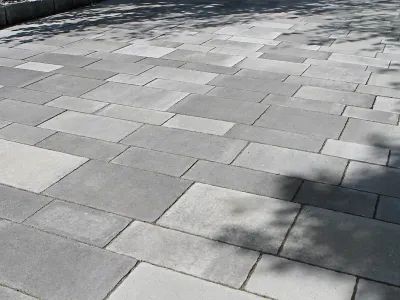 Großflächige Pflasterarbeiten mit modernem Verbundpflaster in Grau für Wege oder Hofeinfahrten.