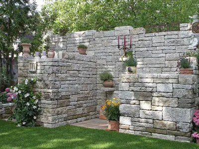 Eine dekorative Sichtschutzwand aus Naturstein verschönert die professionelle Gartengestaltung.