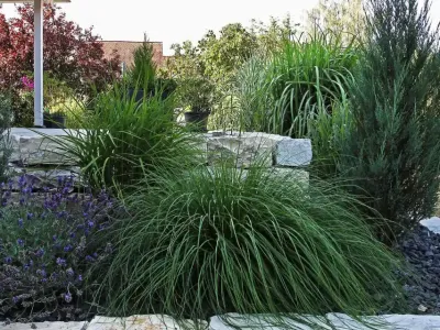Stabile Hangabsicherung aus Naturstein mit Pflanzebenen für eine moderne Gartengestaltung.