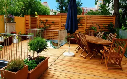 Eine moderne Holzterrasse mit Esstisch, Stühlen und Sonnenschirm. Stilvolle Terrassen aus Holz für gemütliche Stunden.