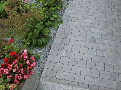 Professionelle Pflasterarbeiten für einen Gartenweg mit modernen Pflastersteinen.