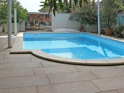 Großzügige Platten als elegante Poolumrandung inmitten einer mediterranen Gartengestaltung.