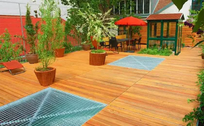 Eine große Holzterrasse mit integrierten Metallgittern und Kübelpflanzen. Moderne Terrassen aus Holz im urbanen Raum.